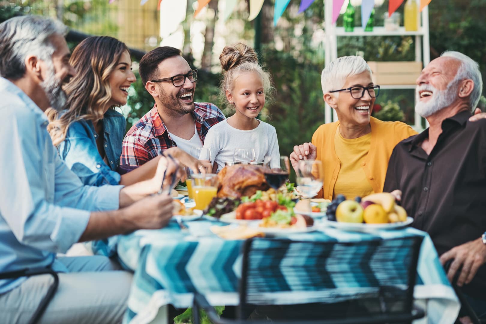 Grandparents, parents, and children enjoy a meal together.