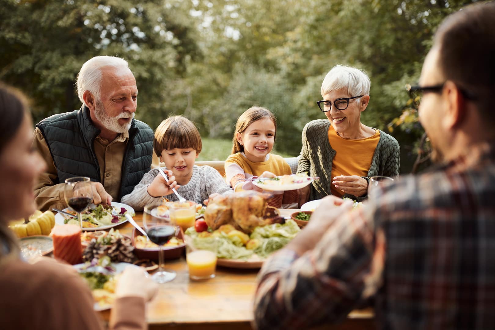 A multi-generational family gathers to share Thanksgiving dinner together.